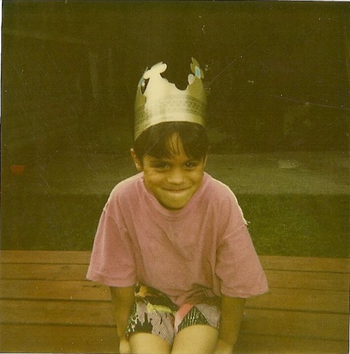 Tony as a child wearing a handmade paper crown